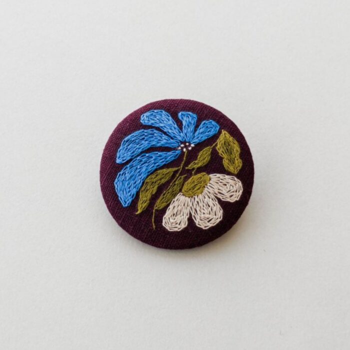 Broche textile avec motif fleur brodé à l'aiguille