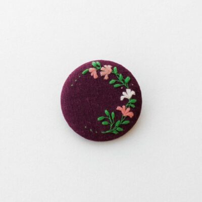 Broche en lin avec motif couronne de fleurs brodé à l'aiguille