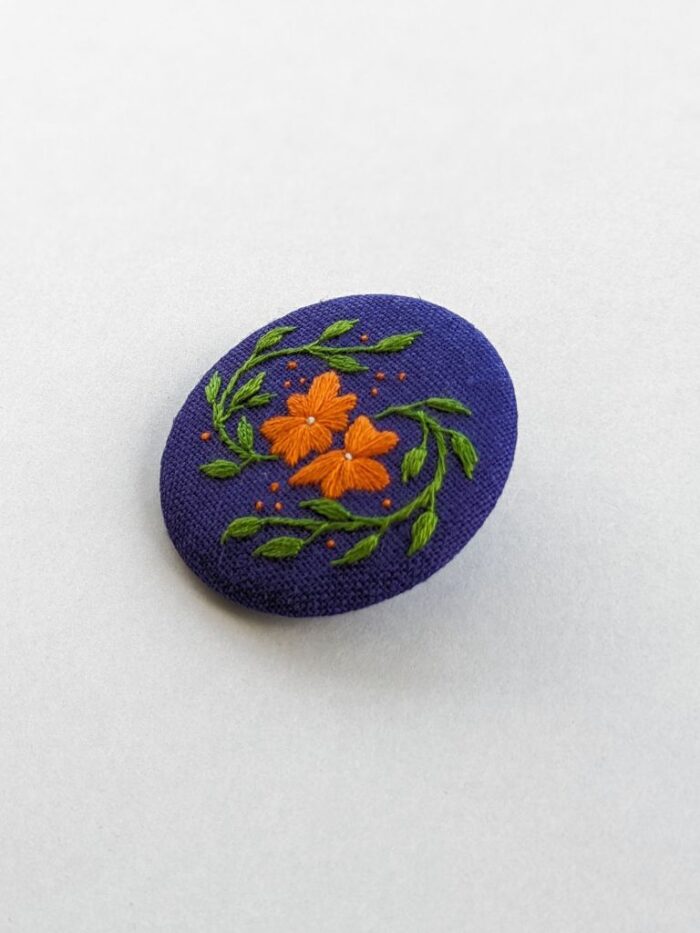 Détail broche en lin avec motif fleur brodé à l'aiguille