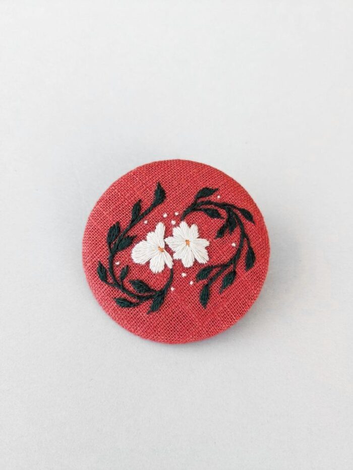 Détail broche en lin avec motif fleur brodé à l'aiguille