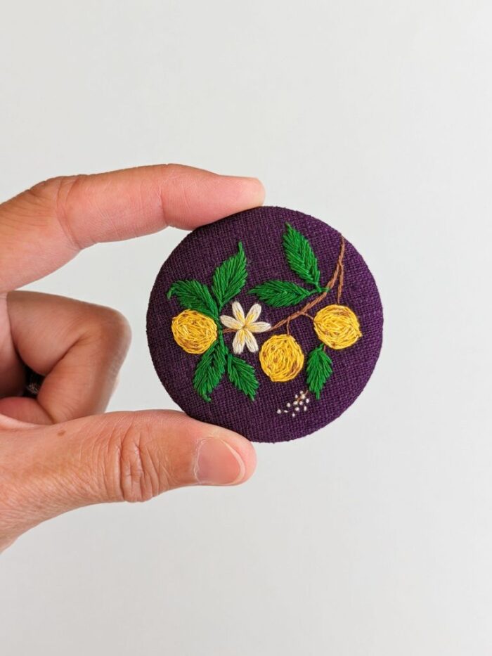 Broche textile avec motif citrons brodé à l'aiguille