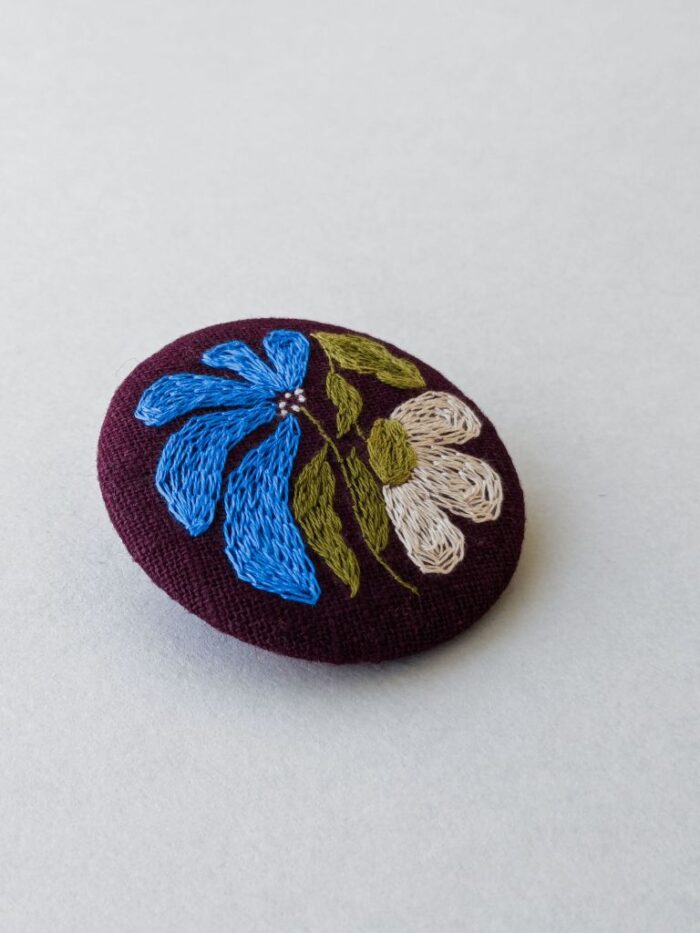 Détail broche en lin avec motif fleur brodé à l'aiguille