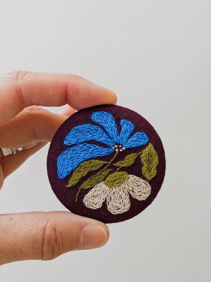 Détail broche en lin avec motif fleur brodé à l'aiguille