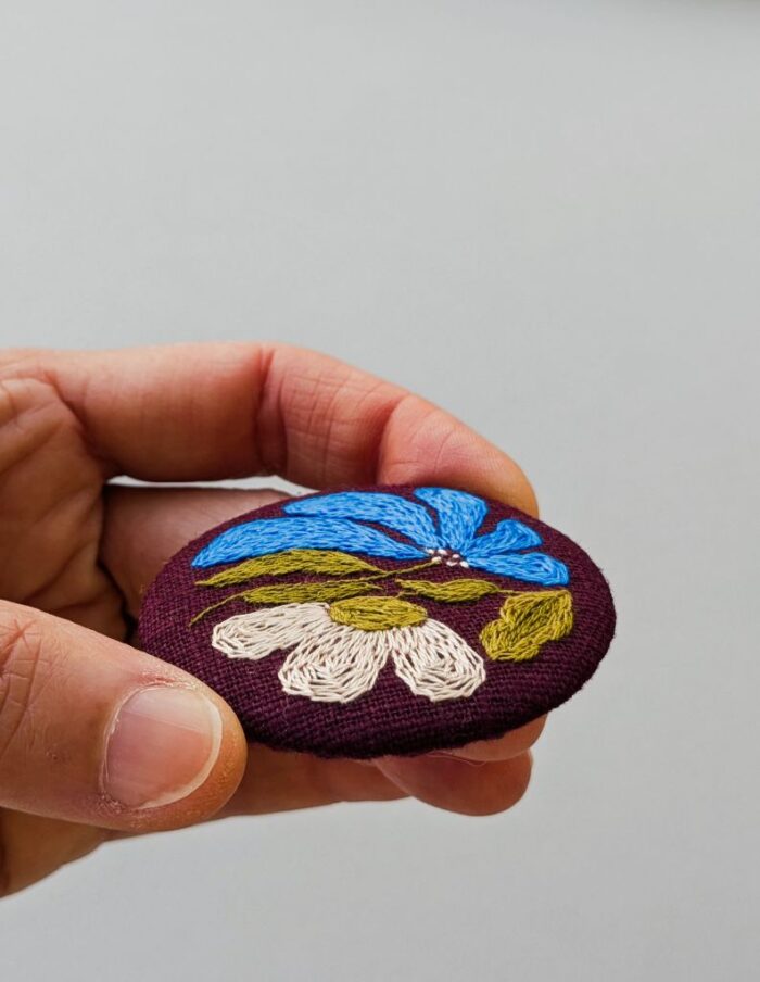 Broche textile avec motif fleur brodé à l'aiguille