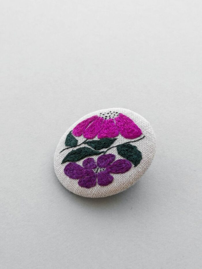 Broche textile avec motif fleur brodé à l'aiguille